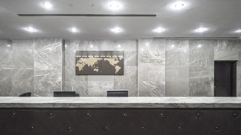 Signalétique d’un immeuble de bureaux : annuaire de hall, plaques d’étage et locataires qui changent tous les deux ans